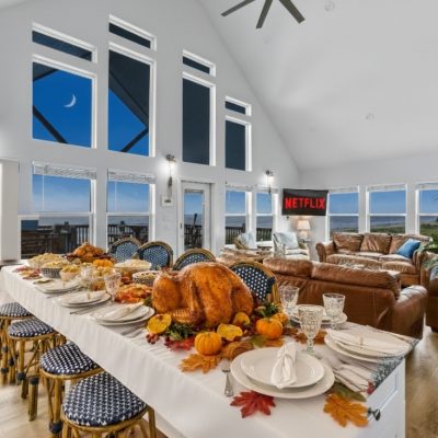 Thanksgiving dinner table set in a beachfront vacation rental with ocean view windows, Crystal Beach Texas