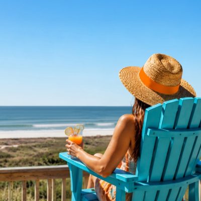 Woman relaxing on a beachfront deck overlooking the Texas coast, Bolivar Peninsula late summer